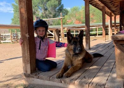 Young Girl with German Shepherd Dog on porch of log cabin - Lazy L&B Dude Ranch Wyoming